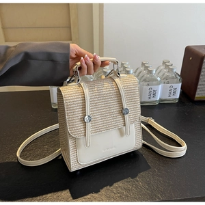 Detail of cream leather flap and woven texture on a casual two-way straw backpack