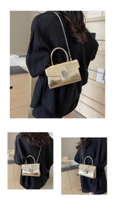 Golden metallic mini chain bag shown on model highlighting the chic compact size and glossy texture