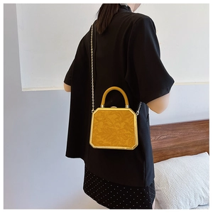 Detailed back view of a yellow octagonal crossbody bag with floral relief and chain