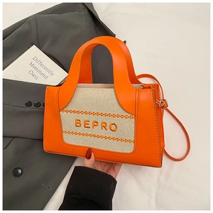 Détail de la texture cuir orange et toile beige avec logo BEPRO brodé sur le sac
