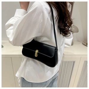 Detail of a black underarm bag featuring a smooth leather finish and golden metal buckle