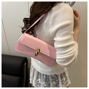 Pink baguette shoulder bag with gold metal buckle shown on model in white knitwear