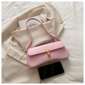 Detail of cherry pink baguette underarm bag with gold metal buckle on beige blazer
