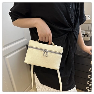 Macro detail of creamy white lychee grain leather mini bag with silver metal zippers
