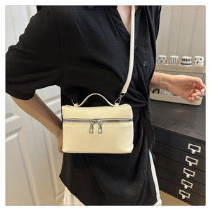 Lifestyle shot of an off-white lychee leather mini square bag with silver hardware detail