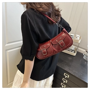 Sac à bandoulière rétro rouge brillant avec deux poches avant porté par un mannequin
