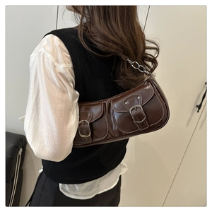 Detail of dark brown glossy PU leather baguette bag with dual utility pockets