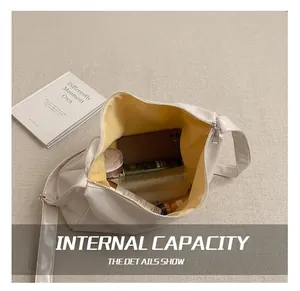 Detail showing spacious interior capacity of the minimalist beige crossbody commuter bag
