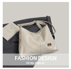 Detail view of cream white large capacity tote bag with wide shoulder strap and logo plaque