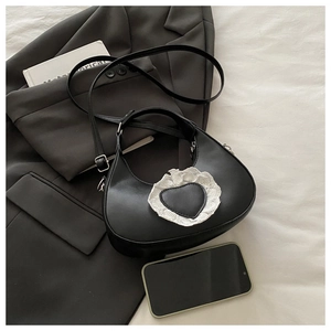 Détail du sac à main cœur noir avec dentelle blanche sur fond de style minimaliste