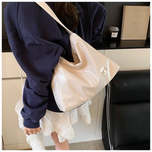 Close-up of glossy white patent leather Hobo bag with large capacity and gold logo detail