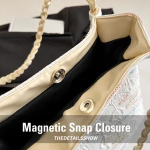 Detail view of cream-white bucket bag with magnetic snap closure and woven texture