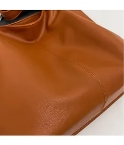 Detail of caramel tote bag featuring premium pebble grain texture and neat stitching