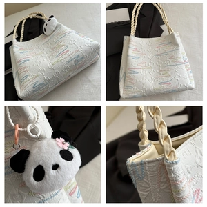 Detail shots of white quilted bucket bag with colorful embroidery and panda charm