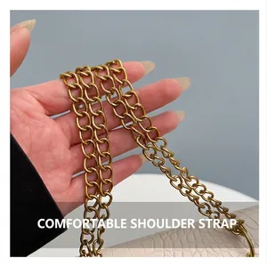 Close-up of matte gold metal chain strap on light-colored crocodile pattern bag