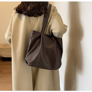 Detail of vintage dark brown tote bag showing soft leather texture and vertical stitching