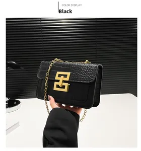 Detail of black crocodile texture bag with gold rectangular interlocking clasp and chain strap