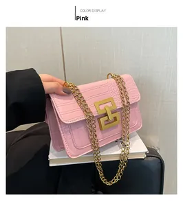 Detail of pink faux crocodile leather bag with gold chain strap and metallic buckle
