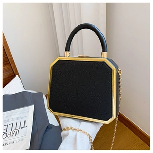 Detail of black hexagonal box bag with floral embossing and golden metal frame