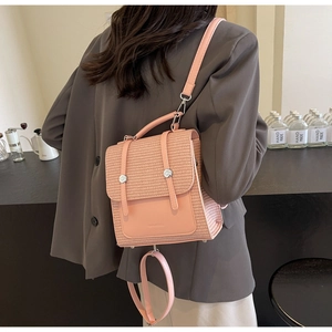 Pink straw backpack featuring leather straps and dual buckle closure for a casual look