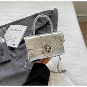 Close-up of silver patent leather bag with metallic crinkle texture and turn-lock