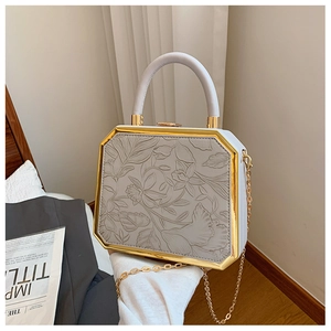 Detail of octagonal box bag featuring 3D floral embossing and gold metal frame finish