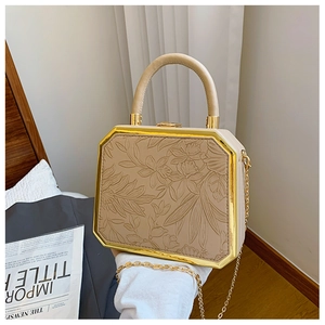 Detail of khaki floral embossed octagonal handbag with gold metal frame and chain strap