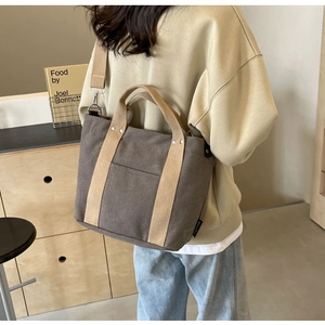 Dettaglio posteriore della borsa tote in tela con manici kaki e tracolla rimovibile