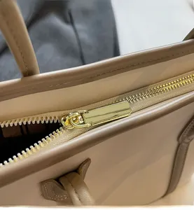 Détail de la fermeture éclair dorée et du cuir de qualité supérieure du sac beige
