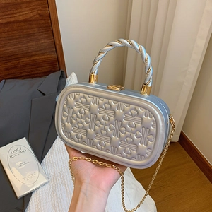 Bolso de noche rígido plateado con relieve de corazones y asa metálica trenzada