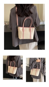 Détails du sac cabas beige avec bordures roses et boucles métalliques dorées