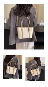 Détail du sac cabas beige et marron montrant les poignées et la bandoulière réglable