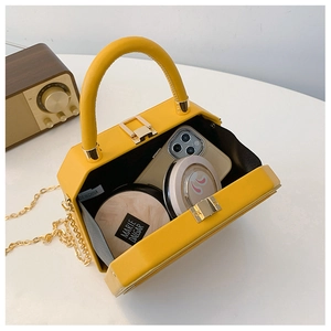 Interior view of a bright yellow box bag showing storage for a phone and cosmetics