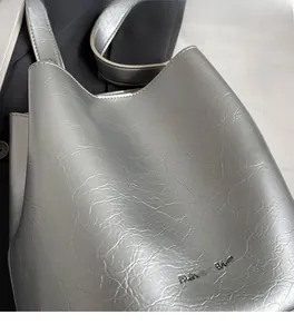 Détail du sac cabas argenté avec texture métallisée plissée et logo FASHION & BAGS