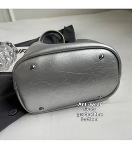 Vue détaillée du fond d'un sac seau argenté avec rivets de protection et cuir texturé