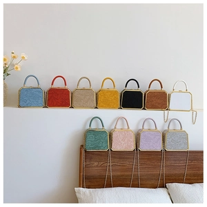 Detail of floral embossed box bags in eleven colors with gold chain and metal handle