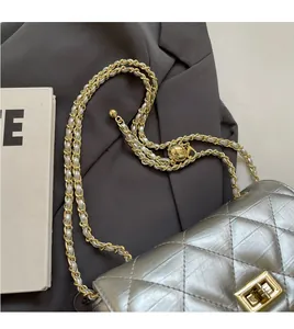 Detail of silver quilted crossbody bag with golden chain and adjustable ball buckle