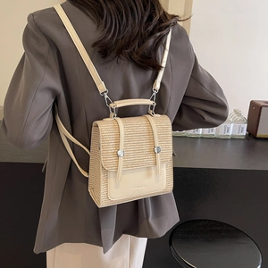Straw and white leather mini backpack worn by model in a minimalist stylish indoor setting