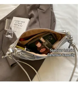 Detail view of spacious interior in silver crescent bag with daily essentials storage