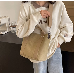 Dettaglio della borsa tote in tela kaki con tracolla regolabile e fibbie laterali