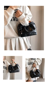 Close-up of black glossy pleated bucket bag featuring elegant beaded handle and drawstring detail
