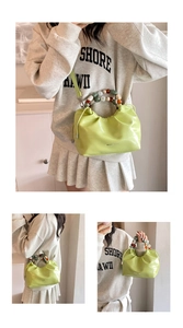 Detail of lime green pleated bucket bag with colorful marble bead handle and glossy finish