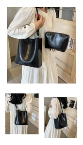 Détails d'un sac seau noir en cuir grainé avec pochette assortie et logo doré chic