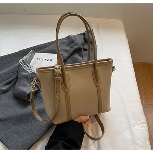 Détail du sac cabas kaki avec poignées cylindriques et boucle de réglage en métal doré
