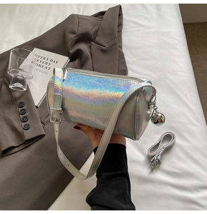Detail of silver holographic cylinder bag with pleated texture and metallic orb charm