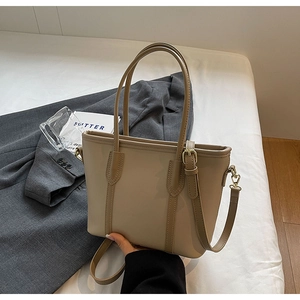 Détail montrant les coutures soignées et le cuir PU lisse du sac fourre-tout beige