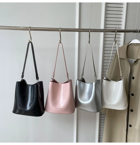 Présentation de sacs seaux élégants en noir, rose, argent et blanc avec textures fines