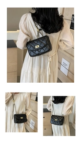 Detail of classic black quilted bag featuring gold chain strap and metal turn-lock closure