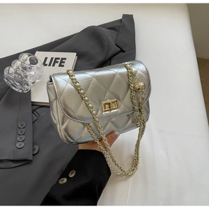 Close-up of silver quilted crossbody bag with gold chain strap and square turn-lock closure