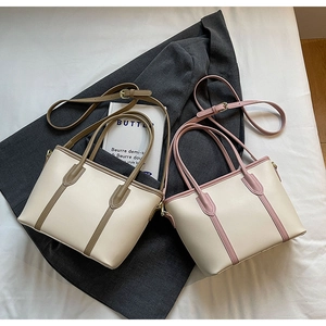 Détail de sacs cabas en cuir PU bicolore beige avec des touches de rose et de kaki